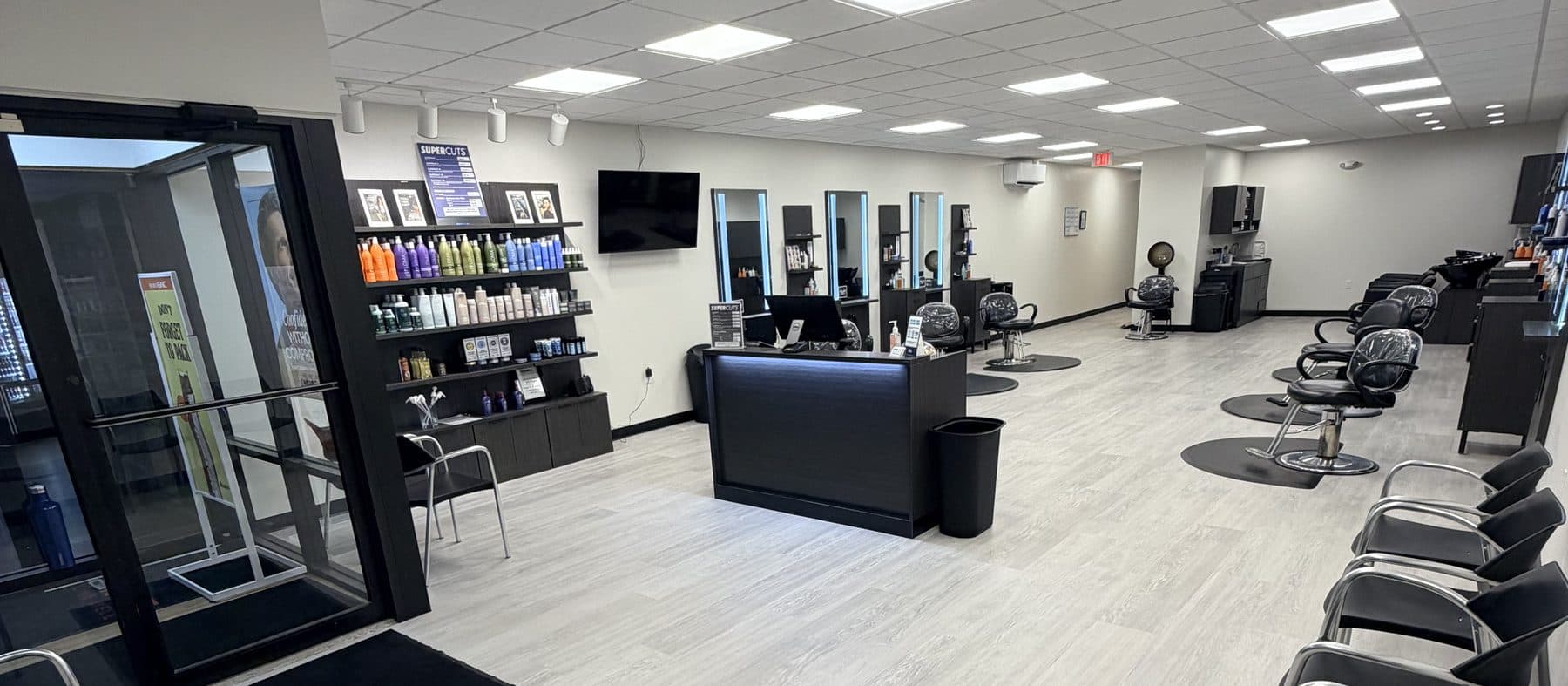 A bright, newly opened MjjM salon with black styling chairs, product shelves and a reception desk